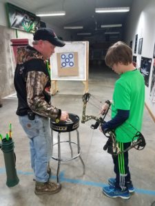 Tim doing an archery instruction with Brody